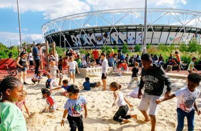Kids playing in the sand in front of the Stadium