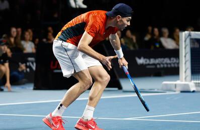 A tennis player plays a shot