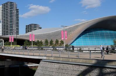 A photo of the exterior of the London Aquatics Centre on a sunny day
