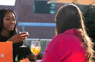 Two women sit on the Haugen rooftop bar with cocktails