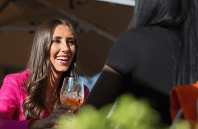 Two women enjoying cocktails on a rooftop