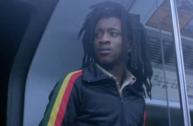 A man with dreadlocks stands on the tube