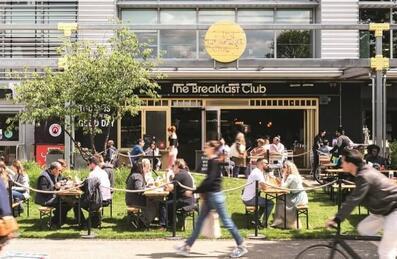 people on beer garden benches socialising in the sun