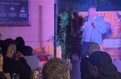 A man on stage at a comedy night