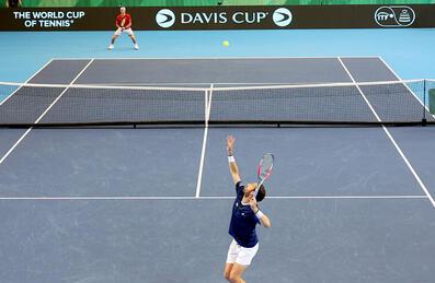 a player serves at David Cup match