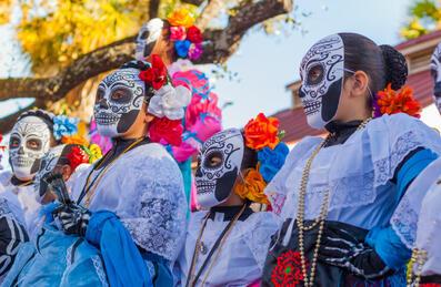 A group of people wearing traditional day of the dead masks