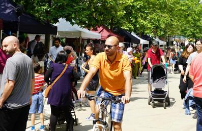 A crowd of people walk through a street food festival