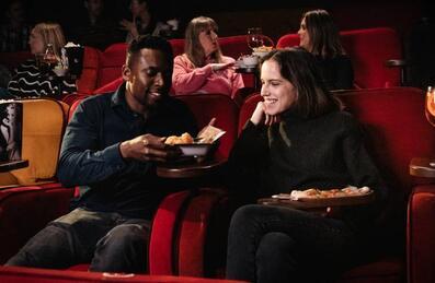 People sat at Every Cinema Stratford International eating food and watching a film