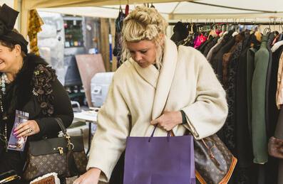 Two people shopping at a vintage stall at a market