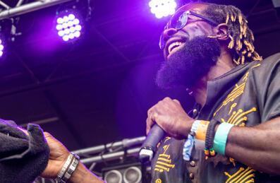 A musician on stage laughing and holding a microphone