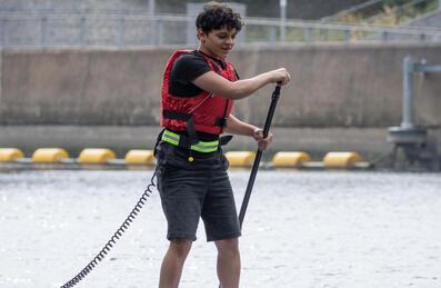 A young adult on a paddle board