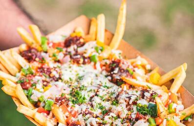 Someone holding a box of loaded fries.