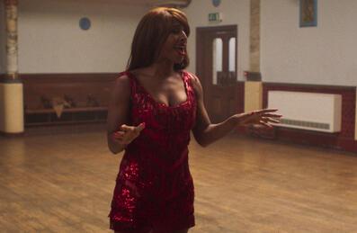 A women sings in a red sparkly dress