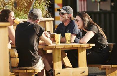Four people sit outside at Riverside East