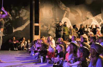A performer singing in front of a crowd of children