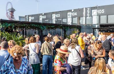 A group of people on the terrace of Snoozebox with the hotel in the background