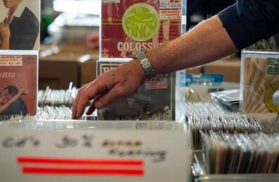 someone reaches into a box of records