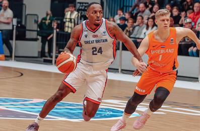 A GB Basketball player moves with the ball past an opposition player