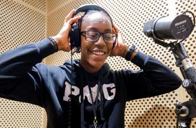 A young person in a recording booth