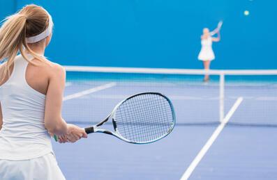 A tennis player readies herself to return a ball