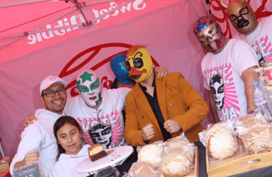 Masked people pose for a photo in a food stall