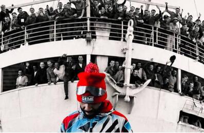 A person stands in front of a boat of people
