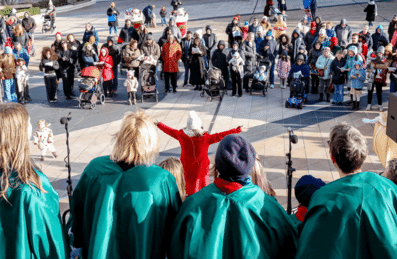 The back of a choir performing for a crowd