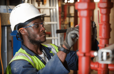Photo of a construction worker working on some pipes