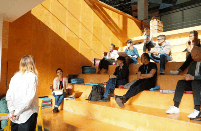 People presenting in a theatre style space