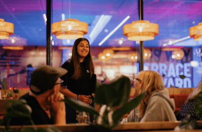 Photo of a server talking to two customers at Riverside East