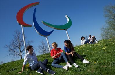 People sitting in front of the Paralympics symbol