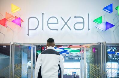 Man walking into building with Plexal sign
