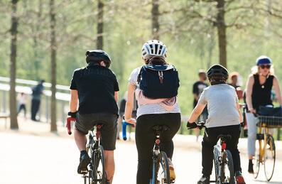Family cycling through the Park in the sunshine