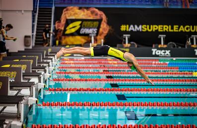 Athlete diving off the starting blocks into a pool