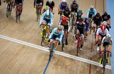 Group of cyclists crossing the finish line on a velodrome track