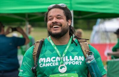 A man celebrates finishing the Macmillan Mighty Hike with a medal