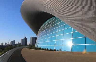 An outside photo of the London Aquatics Centre showing the blue windows