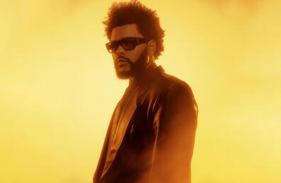 The Weeknd in front of a yellow background