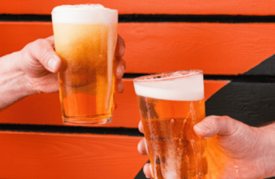 Two hands holding a beer in front of an orange background