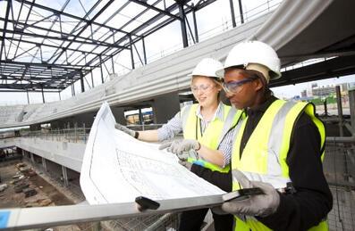 Two young construction engineering professionals in PPE