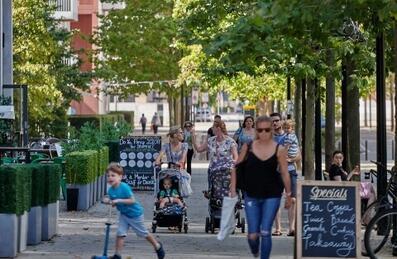 Families walking outside East Village in the summer
