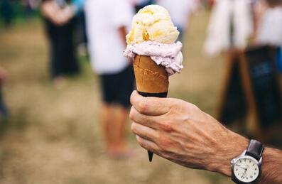 A man holding an ice cream outside