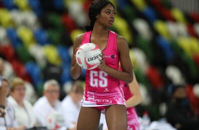 A Netball player holds the ball ready to throw