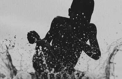 a silhouette splashes water