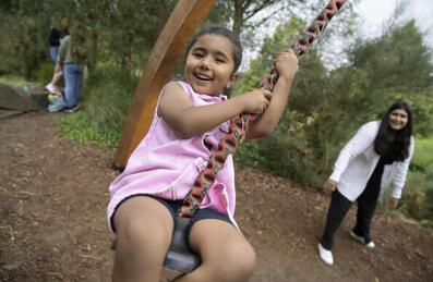 A child on a swing playing in a playground