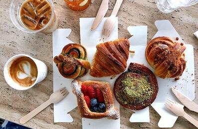 Overhead shot of pastries and coffee with wooden utensils