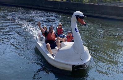 A Family riding a large swan pedalos on river of Queen Elizabeth Olympic Park