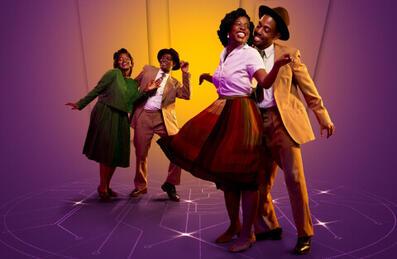 Four people dance together with a purple background