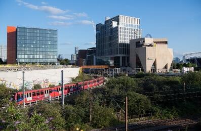 A train travels past new buildings