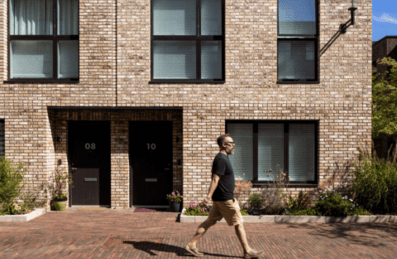 Man walking infront of houses